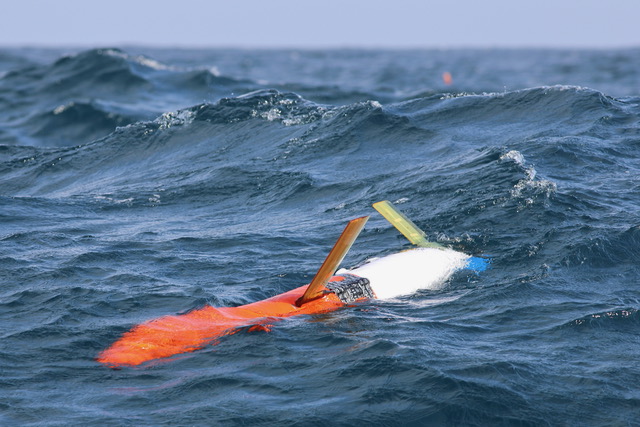 Orange and white spray 2 glider on the ocean surface