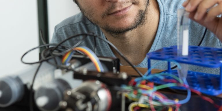 _DSC0493 engineer works on an open sensor with different colored wires in the foreground